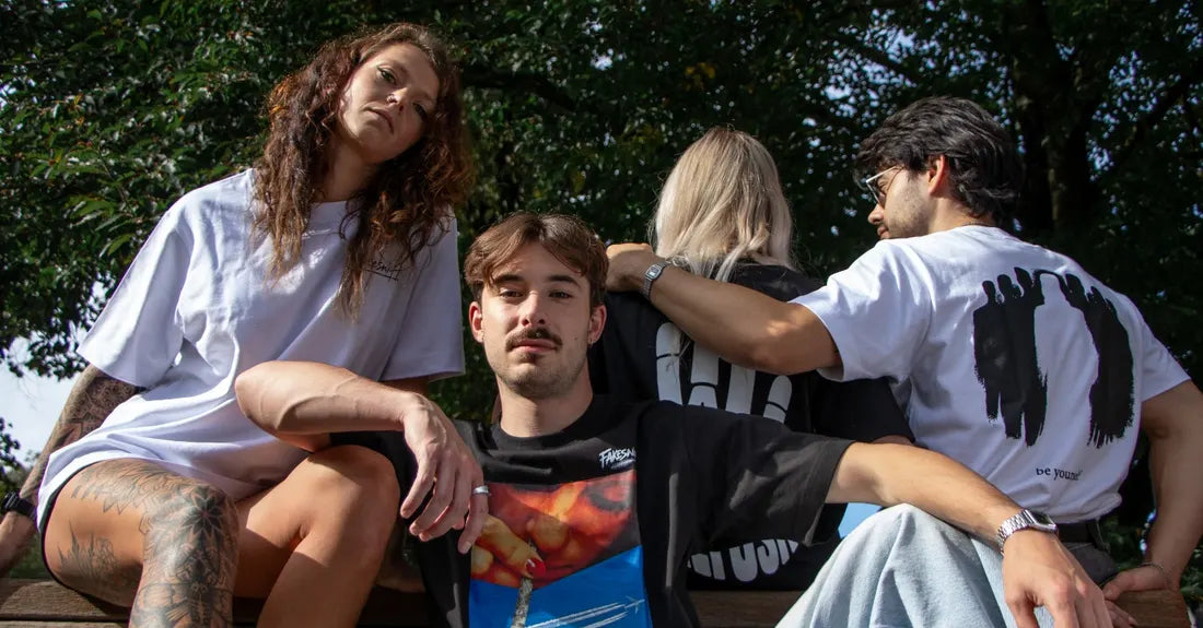 Four people on a bench under the trees.