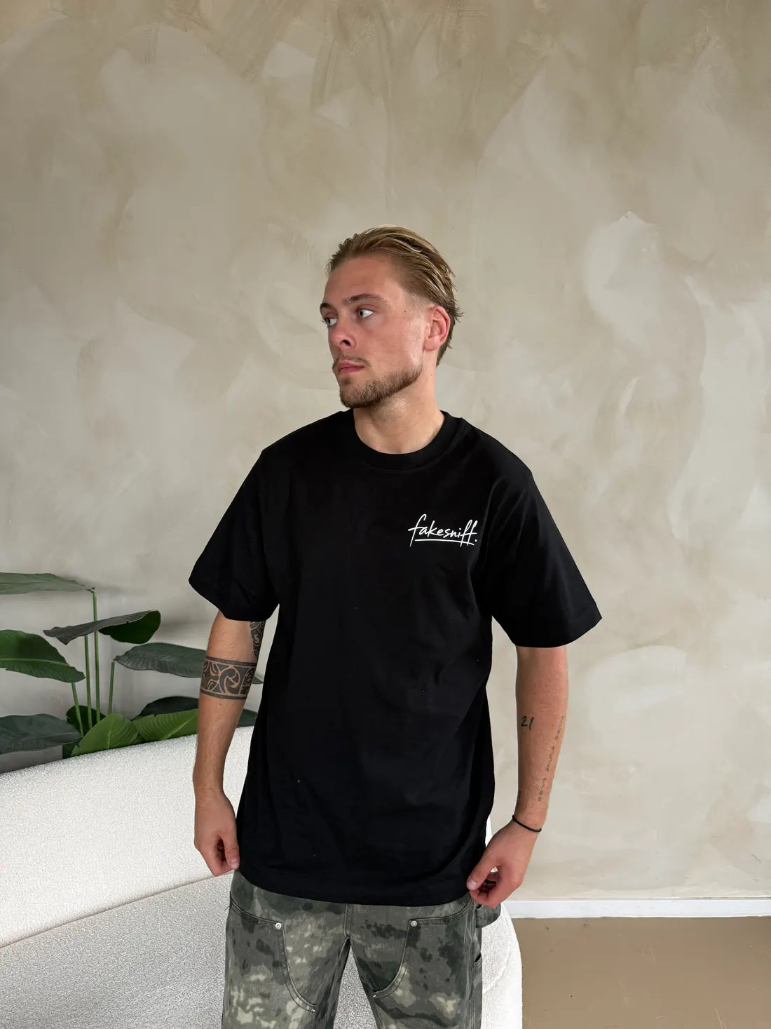 A man in a black shirt with only the small logo on the chest.